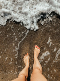 Low section of woman standing on beach