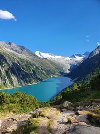 Scenic view of lake and mountains against blue sky