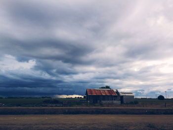 Rural landscape against cloudy sky