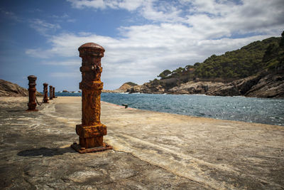 Cross on beach against sky