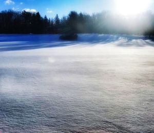 Snow covered landscape against blue sky