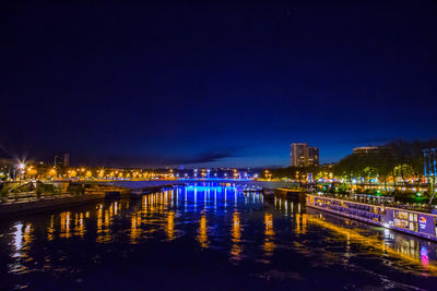 Illuminated bridge over river at night