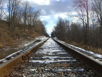 Railroad track against cloudy sky