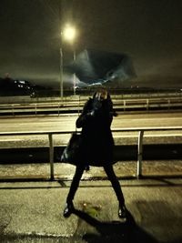 Rear view of man against sky at night