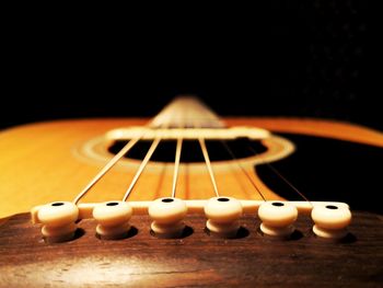 Close-up of guitar against black background