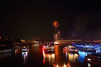 Firework display over river in city at night