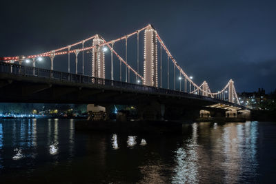 View of bridge over river at night