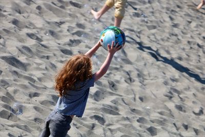 Girl playing on sand at beach