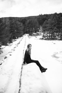 Woman on snow covered mountain against sky