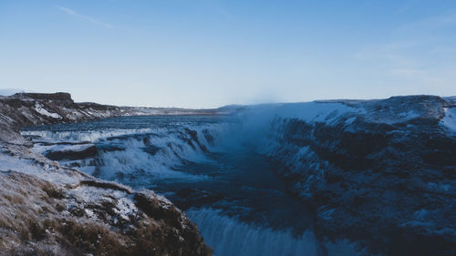 Scenic view of waterfall against sky