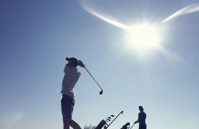 Friends playing golf clear blue sky during sunny day