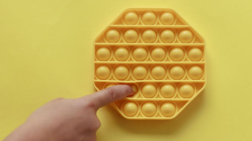 Close-up of hand holding yellow paper