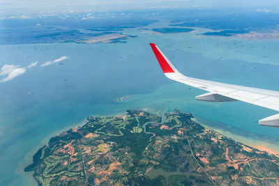 Aerial view of airplane wing over sea