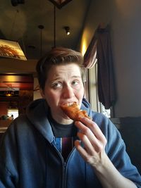 Portrait of man eating at home