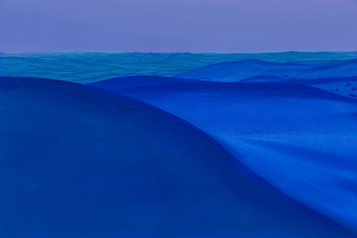 Digital composite image of sand dunes in desert at night