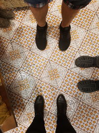 Low section of man standing on tiled floor