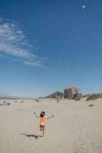 Boy flying kite on sunny day at beach