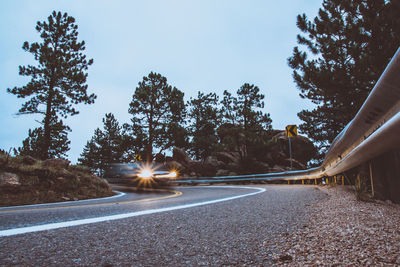 Road amidst trees against sky