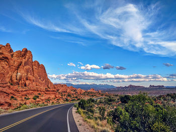 Road leading towards mountains against sky