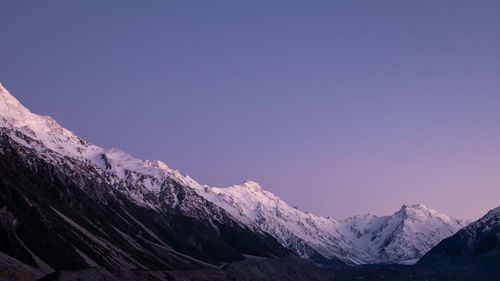 Scenic view of snowcapped mountains against clear blue sky