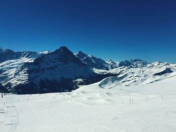 Scenic view of snowcapped mountains against clear blue sky