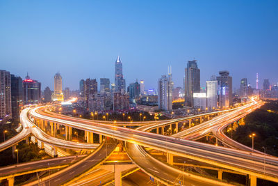 High angle view of illuminated city street and buildings against sky