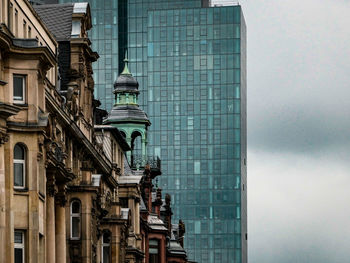 Low angle view of modern building against cloudy sky