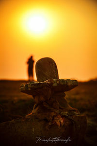 Close-up of stone stack on rock against sky during sunset