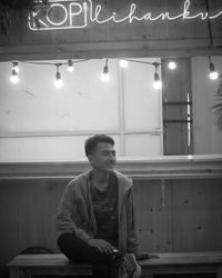 Young man looking away while sitting in restaurant