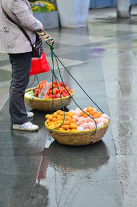 Low section of woman with fruits for sale at market stall