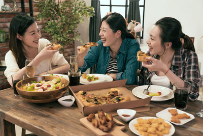 Friends having food on table at restaurant