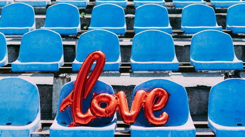 View of balloons on blue chairs at stadium