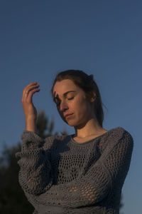 Woman looking at camera against clear sky