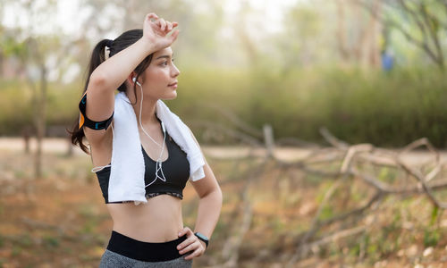 Side view of young woman standing on field