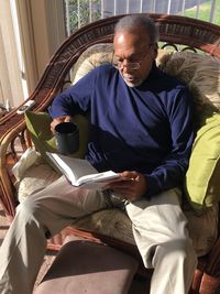 High angle view of man reading book at home