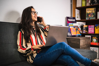 Young woman using mobile phone at home