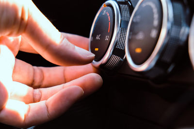 Close-up of person by knob in car