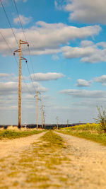 Surface level of electricity pylon on field against sky