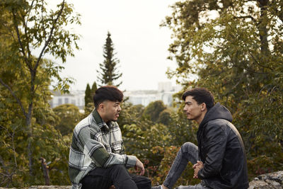 Young men sitting on rocks and talking