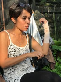 Woman with fractured hand sitting outdoors