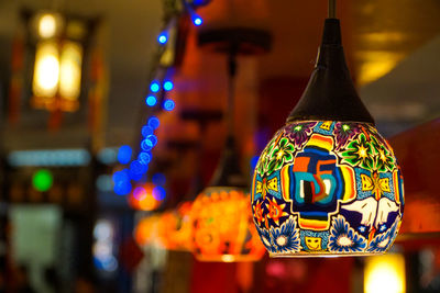 Close-up of illuminated lighting equipment hanging at night