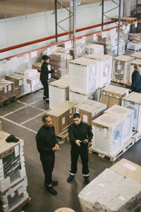 High angle view of manual workers working in logistics warehouse