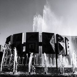 Water splashing on fountain against sky