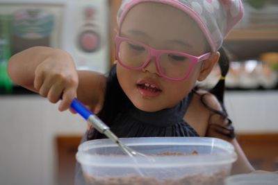 Close-up of cute girl preparing food on table