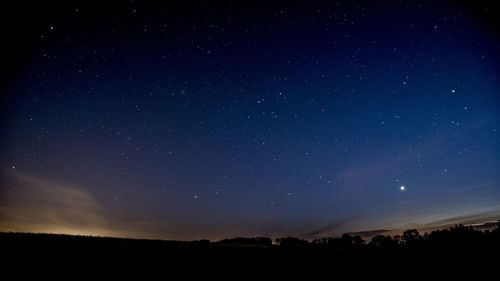 Scenic view of silhouette landscape against star field at night