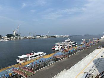 Pier by harbor against sky in city