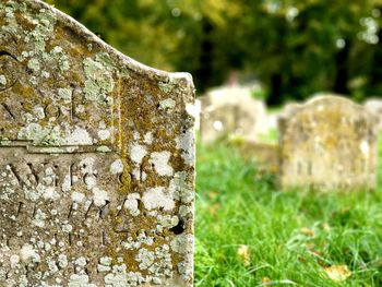 Close-up of stone cross on field