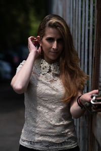 Portrait of beautiful woman standing against blurred background