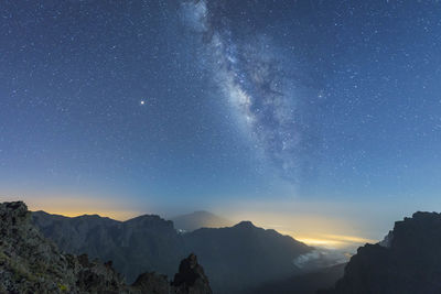 Scenic view of mountains against sky at night