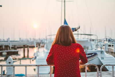 Rear view of woman standing at harbor